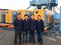 中国石油西部钻探某钻井队电站前，易总与员工亲切合影